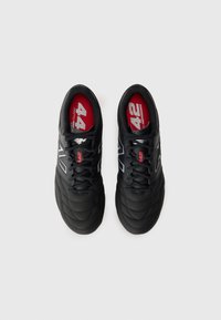 Black athletic shoes featuring padded texture, laces, and a red insole with the number 42. Silver accents highlight the branding.