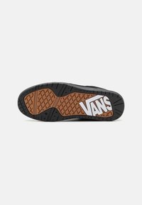 Crna gumena potplata tenisice s dijamantnim uzorkom i smeškastim akcentima. "VANS" logo u beloj boji sa strane. Izdržljiv materijal za prianjanje.
