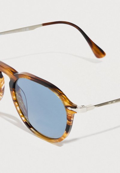 Occhiali da sole tartarugati con lenti blu, montatura rettangolare e dettagli in metallo. Caratterizzati da una texture liscia e aste sottili e curve.