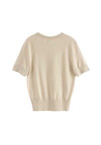 Maglietta beige a maniche corte in maglia con scollatura tonda. Presenta polsini e orlo a coste, con leggere fessure laterali per facilitare il movimento.