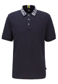 Námořnicky modrá polo tričko s krátkým rukávem, se zapínáním na tři knoflíky a kontrastním límcem, na kterém je text "HUGO BOSS".