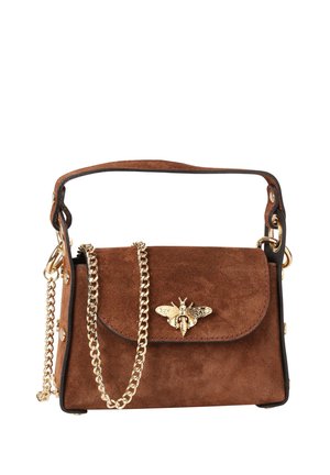 Sac à main en daim marron avec une bandoulière chaîne dorée et un emblème abeille doré sur le rabat avant, avec une poignée courte et une forme structurée.
