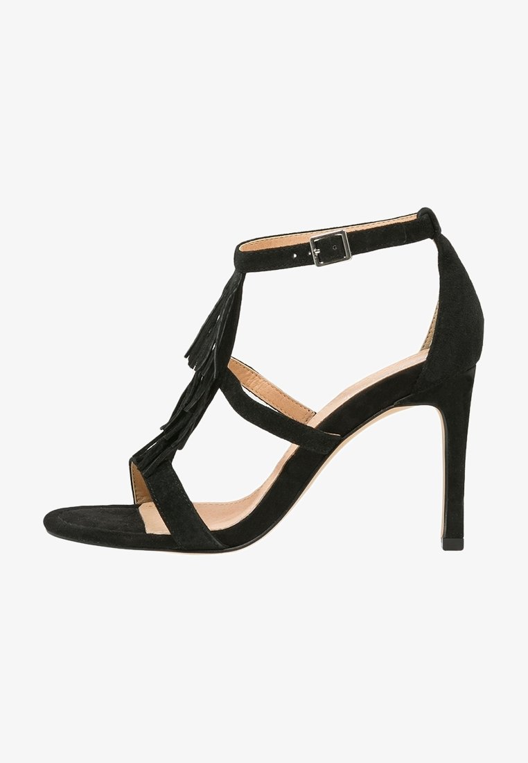 Sandale à talon haut en daim noir avec bout ouvert, bride à la cheville, détails à franges à l'avant, et talon aiguille fin.