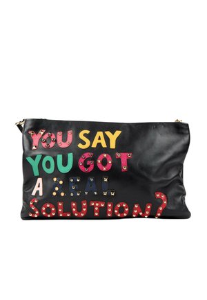 Schwarze Ledertasche mit bunten, genietet Buchstaben, die "You say you got a real solution?" auf der Vorderseite buchstabieren.
