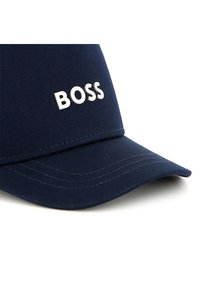 Casquette de baseball marine avec le logo "BOSS" en blanc, design structuré, visière courbée, fabriquée en tissu durable avec des détails de couture visibles.