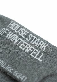 Gray fabric featuring white text that reads "HOUSE STARK OF WINTERFELL." Close-up of the knit material and lettering details.