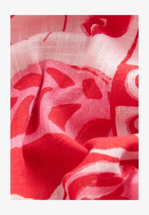 Tessuto a motivi rossi e rosa con una texture leggera e trasparente, che mostra un drappeggio morbido e fluido e elementi di design astratti.