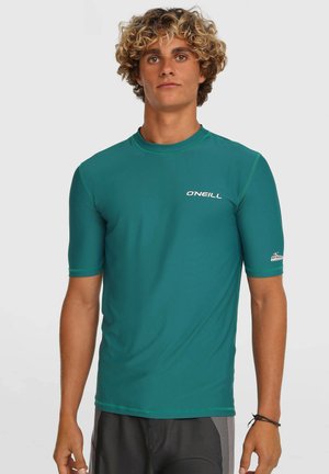 Haut de protection anti-UV à manches courtes de couleur sarcelle avec coutures plates, logo O'Neill sur la poitrine et la manche, fabriqué en matériau extensible et à séchage rapide.