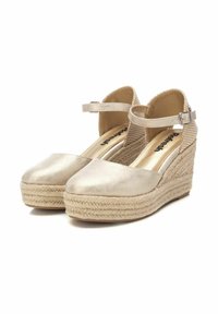 Zapatos de cuña beige con parte superior de tela texturizada, correa en el tobillo y plantilla de yute trenzado. Punta redondeada y forro interior suave.