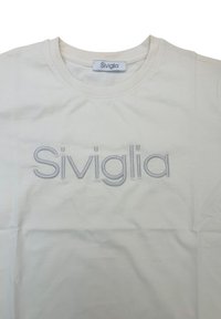 T-shirt in cotone color crema con logo "Siviglia" ricamato di un grigio chiaro. Design a girocollo, texture liscia, lavaggi minimi.