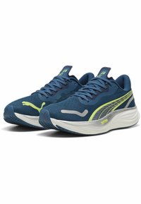 Scarpe sportive blu realizzate in mesh traspirante con suole in gomma. Presentano un accento giallo brillante e un marchio argentato sul lato.