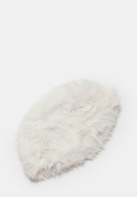 Chapeau en fausse fourrure, forme ovale, texture douce et blanche, matériau épais et duveteux avec des variations subtiles de teinte, sans matériel ni accents visibles.