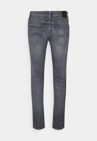 Tmavě šedé džíny z denimu s úzkým střihem, dvěma zadními kapsami, mírně vybledlou texturou a černou nášivkou na pásku.