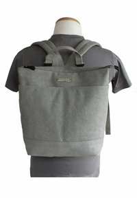 Grau gefärbter Stoff-Rucksack mit verstellbaren Trägern, Reißverschluss oben und einer Vordertasche. Verfügt über verstärkte Nähte und ein metallisches Logodetail.