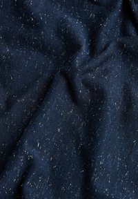 Námořnická modrá tkanina s texturovaným povrchem, s rozházenými stříbrnými vlákny a mírným leskem. Materiál vypadá měkce a zmačkaně.