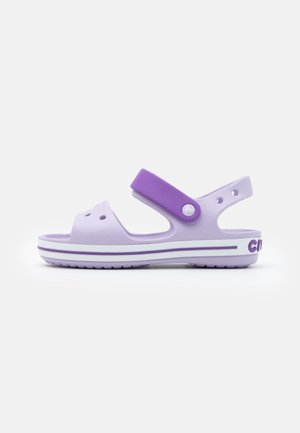 Lichtpaarse open-toe sandaal met een donkerpaarse verstelbare band en een geribbelde zool, ontworpen voor casual gebruik.