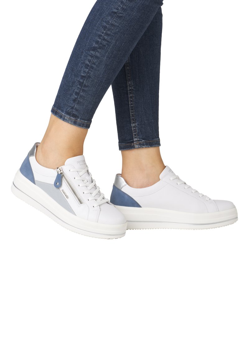 Sneakers bianchi con accenti blu e un tacco argentato, caratterizzati da una chiusura con lacci frontale e una cerniera laterale, realizzati in pelle liscia.