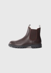 Botas Chelsea de cuero marrón con paneles laterales elásticos y tiradores, con un acabado texturizado y suela de goma negra resistente.
