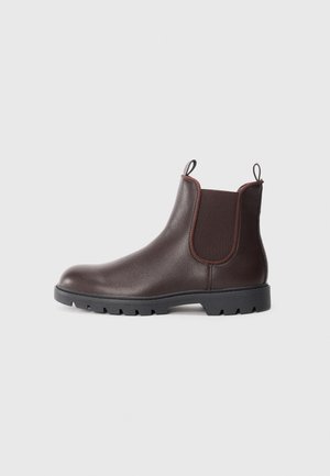 Botas Chelsea de cuero marrón con paneles laterales elásticos y tiradores, con un acabado texturizado y suela de goma negra resistente.