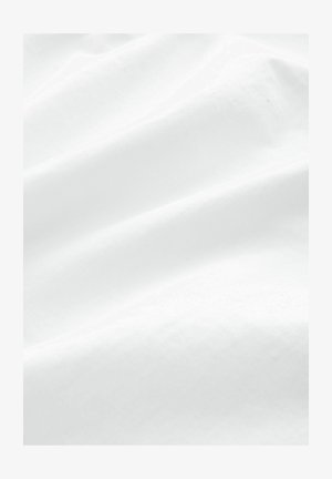 Tissu en coton blanc avec une texture lisse, présentant de multiples plis doux et une apparence uniforme, idéal pour diverses applications textiles.