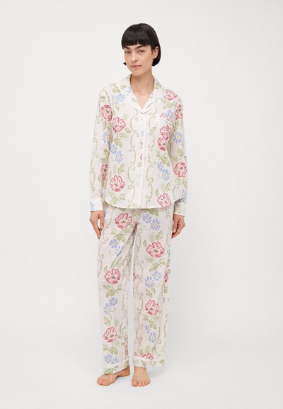 Long-sleeve, button-up pajama set in lightweight, white fabric with floral patterns in pink, blue, and green. Relaxed fit and straight pants.
