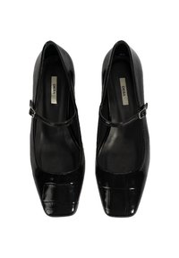 Bottes Mary Jane en cuir verni noir avec un bout carré, une bride au niveau de la cheville et un intérieur lisse. Présente un subtil motif crocodile sur la surface.