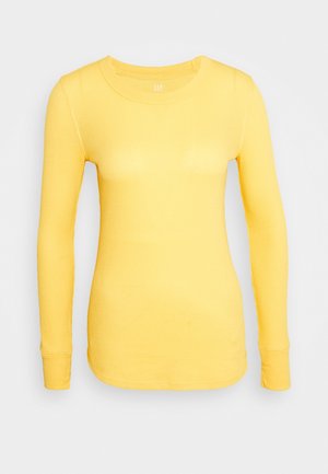 Langärmeliges, geripptes T-Shirt in leuchtendem Gelb, mit Rundhalsausschnitt und figurbetonter Silhouette, verziert mit Nahtdetails entlang der Ärmel und Saumkante.