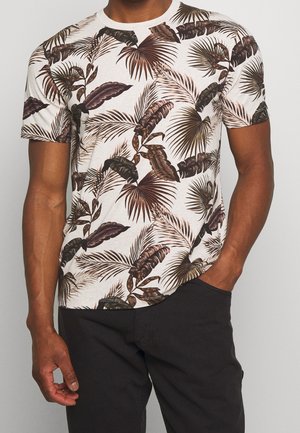 Korte mouwen T-shirt met een crème basis en donkere groene en bruine tropische bladerenpatronen. Ronde halslijn, zachte stof, relaxte pasvorm.