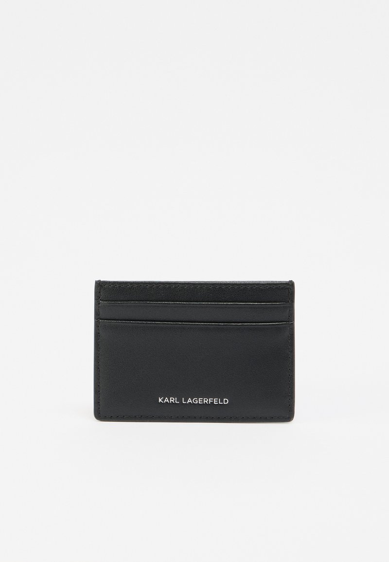 Μαύρο δερμάτινο θήκη καρτών με πέντε θέσεις για κάρτες, λογότυπο με ανάγλυφη χάραξη και λείο υλικό. Απλός ορθογώνιος σχεδιασμός με ελάχιστες ραφές ως διακοσμητικά στοιχεία.