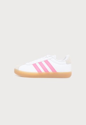 Baskets blanches avec semelle en gomme, trois bandes roses sur le côté, lacets blancs et détail beige au talon, présentées de profil sur fond uni.
