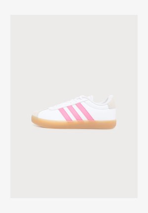Witte sneaker met rubberen zool, drie roze strepen aan de zijkant, witte veters en een beige detail op de hiel, in profiel getoond op een effen achtergrond.