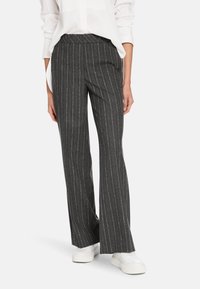Gray pinstriped trousers with a wide leg design, made from smooth fabric, paired with white sneakers. The waistband is flat and fitted.
