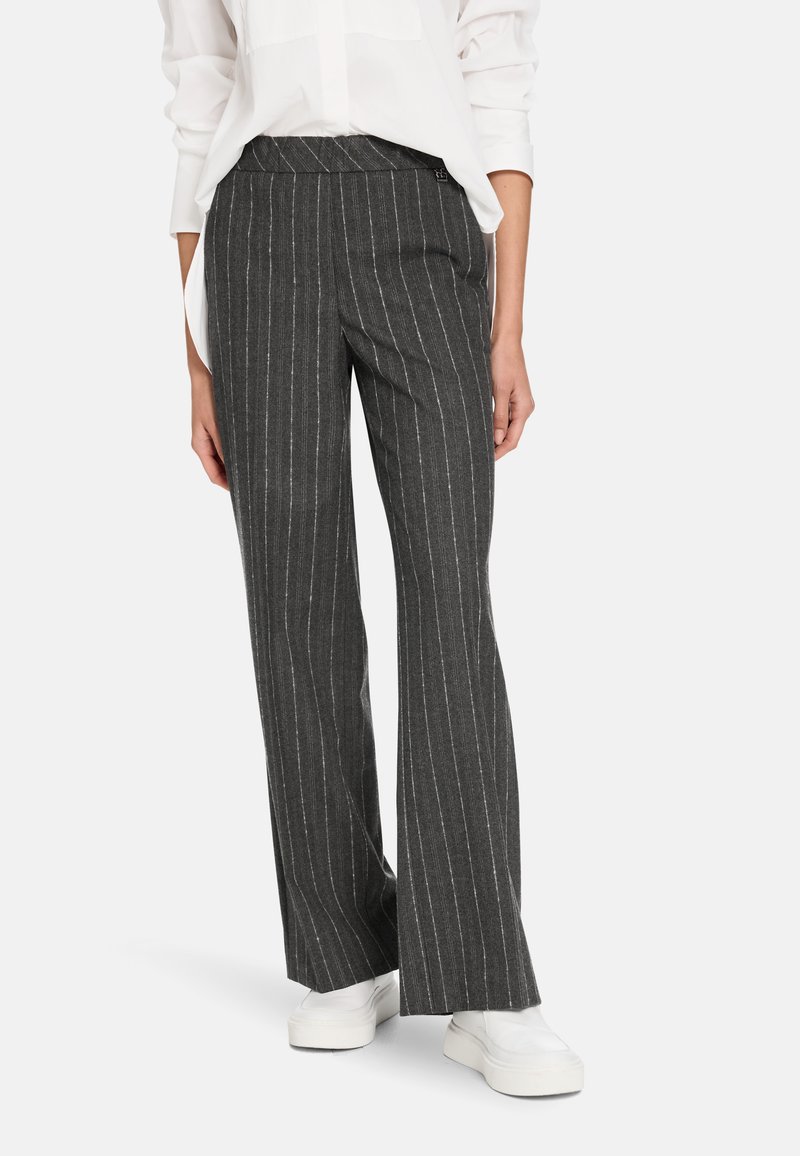 Gray pinstriped trousers with a wide leg design, made from smooth fabric, paired with white sneakers. The waistband is flat and fitted.