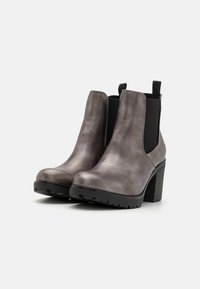 Botines de piel gris hasta el tobillo con un alto tacón cuadrado, punta redonda, paneles laterales elásticos y suela texturizada negra.