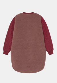 Cappotto lungo con corpo in tessuto teddy fleece marrone e maniche trapuntate rosso scuro con texture, polsini e colletto a coste, mostrato da dietro su sfondo bianco.