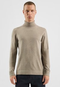 Beżowy sweter z golfem wykonany z miękkiego materiału, z długimi rękawami i dopasowanym fasonem. Gładka tekstura z prążkowanymi mankietami.