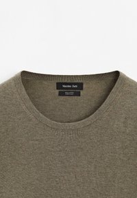 Oliwkowy bawełniany t-shirt z okrągłym dekoltem. Posiada teksturowane wykończenie. Metka informuje o marce "Massimo Dutti" oraz składzie materiału.