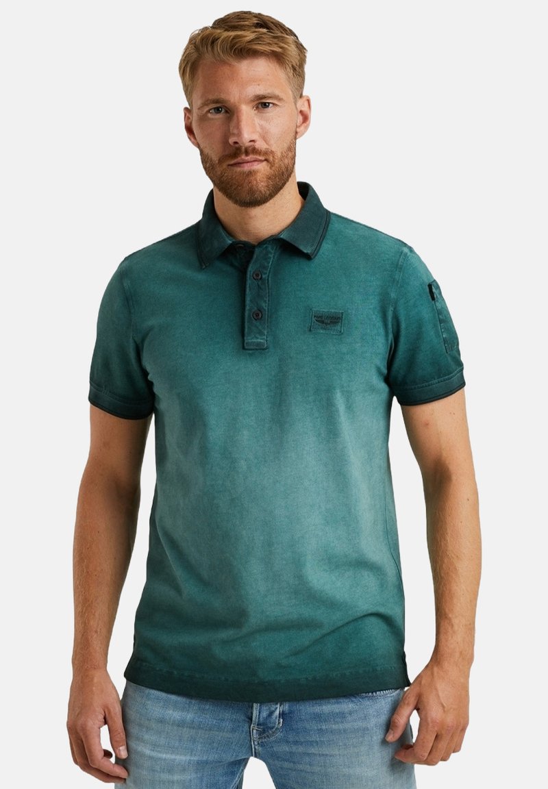 Kurzarm-Polohemd in einem Farbverlauf von Petrol, aus weicher Baumwolle gefertigt, mit einer Knopfleiste und einem Logo-Patch auf der Brust. Mit Kragen.
