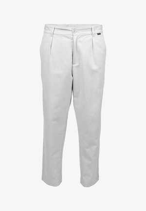 Białe, dopasowane spodnie z plisami z przodu, zapięciem na guziki, szlufkami na pasek i bocznymi kieszeniami, przedstawione na jednolitym białym tle.