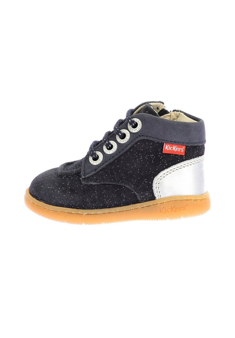 Bota de ante negro con una textura brillante, acentos plateados, diseño de cordones y suela de goma. Presenta puntera redondeada y ojales de metal.