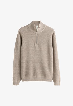 Beige strikket sweater med lange ærmer og en kort foran lynlås, der strækker sig fra en ribbet opretstående krave.