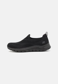 Black slip-on shoe with a textured knit upper and flexible rubber sole. Features a pull tab at the heel for easier wear.