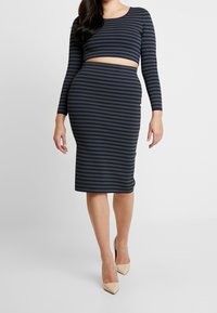 Two-piece outfit featuring a cropped top and a knee-length pencil skirt. The fabric is striped in navy and olive green.