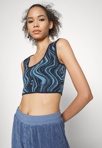 Top curto azul-marinho com padrão de ondas em azul claro, feito de tecido texturizado, apresentando decote quadrado e alças largas.