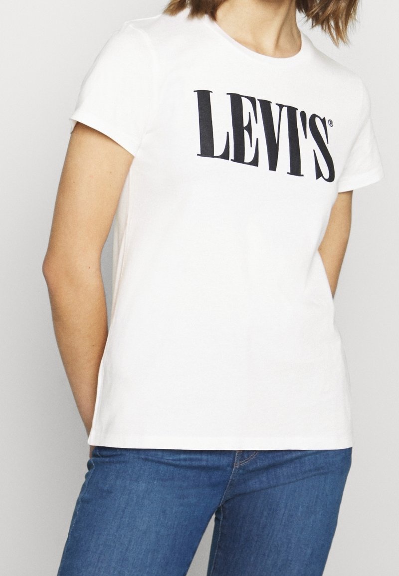 T-shirt en coton blanc à manches courtes avec un logo noir "LEVI'S" sur la poitrine, un col rond et une coupe ajustée.