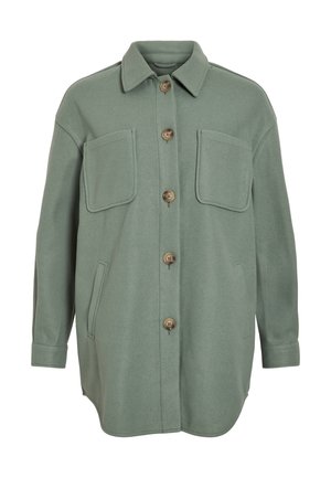 Veste en mélange de laine verte avec un devant à boutons, deux poches poitrine et des poches latérales. Coupe oversize avec un col pointu et des manches longues.