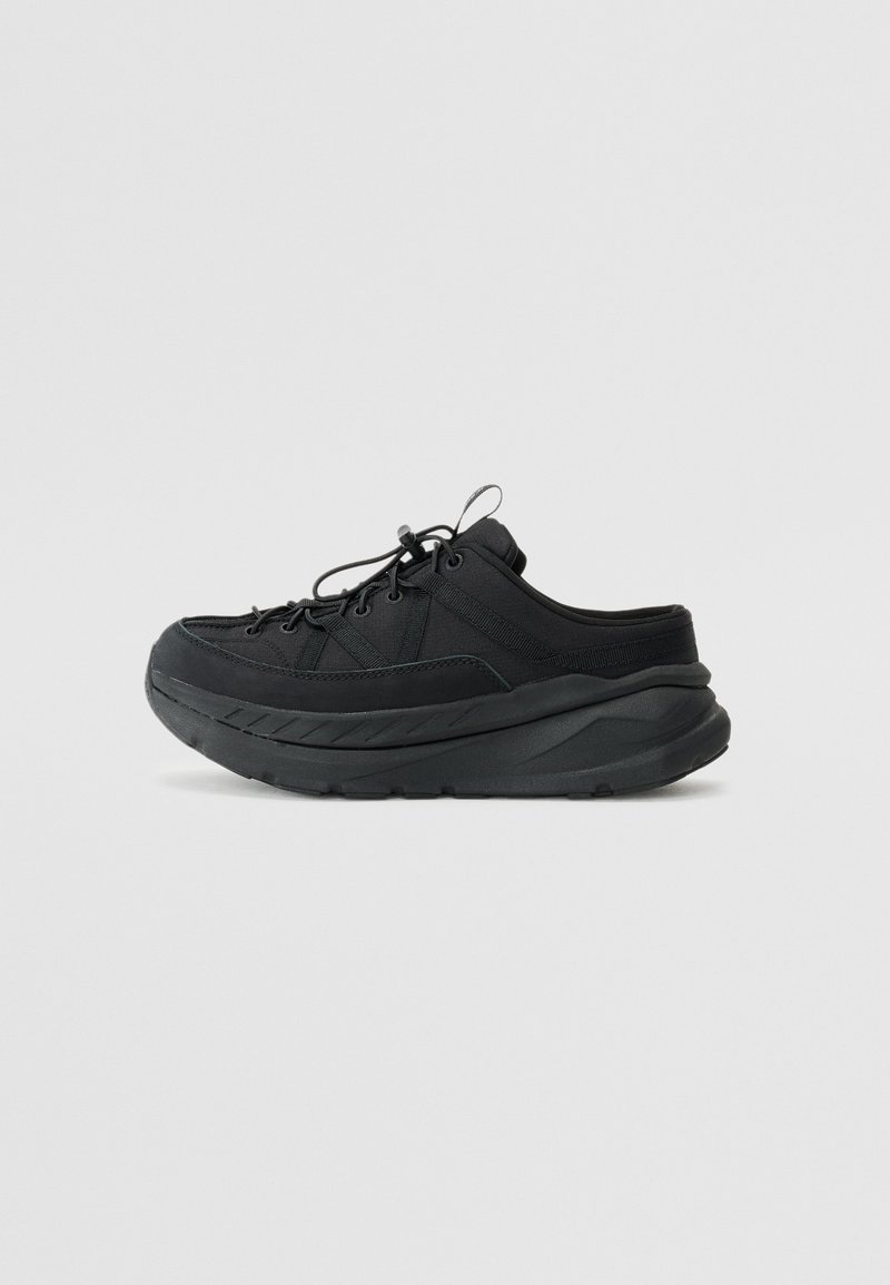 Black athletic shoes with a thick sole, textile upper, rounded toe, cord lacing, and subtle side stitching detail.