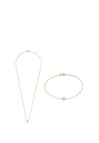 Goldene Halsketten- und Armband-Set mit einem kleinen Kristallakzent am Armband. Glatte Textur, einfaches Design und filigrane Glieder.