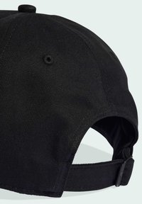 Gorra negra hecha de tela texturizada, con visera curva, correa ajustable y un detalle de botón en la parte superior. Diseño limpio y sencillo.