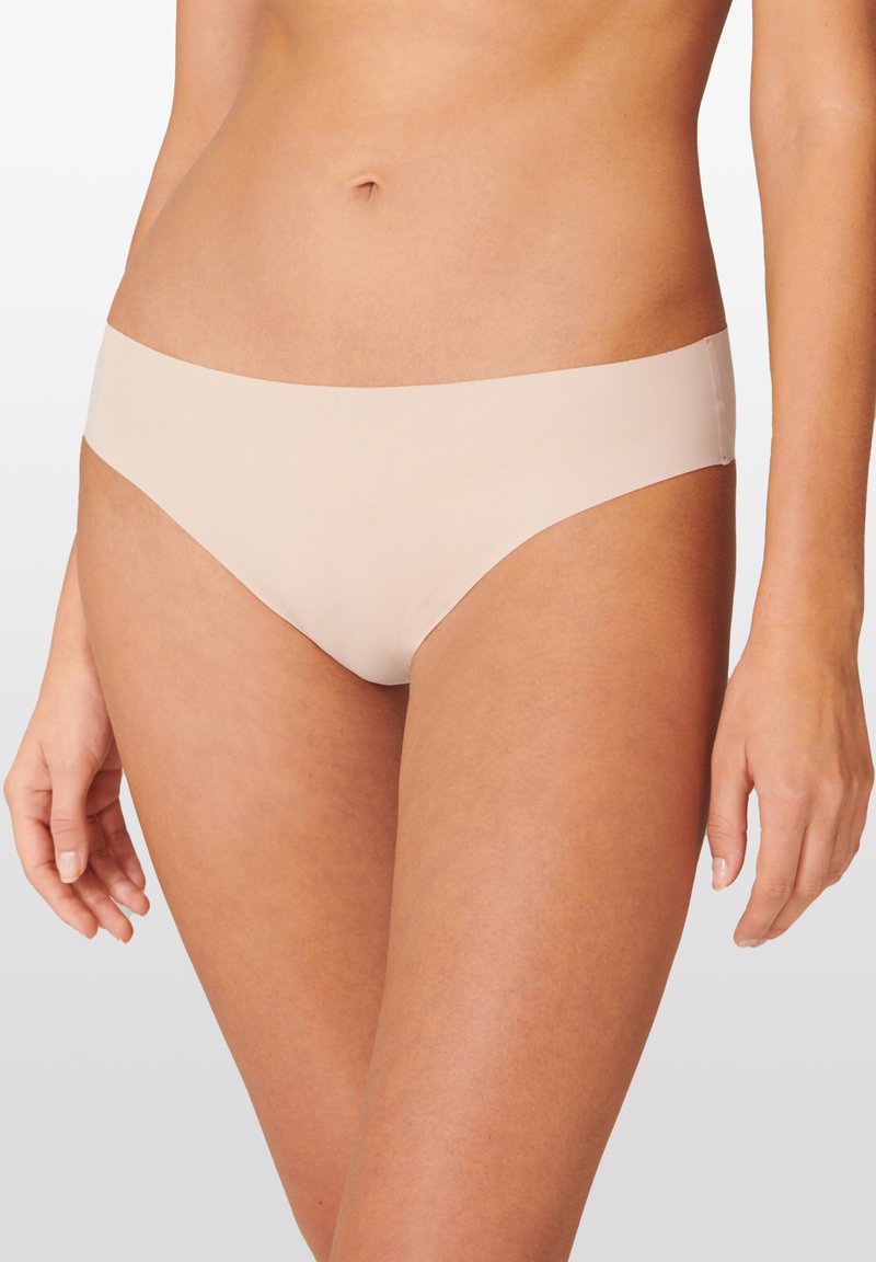 Beige saumaton bikini dengan desain rendah, terbuat dari kain yang halus. Menampilkan gaya minimalis tanpa jahitan atau perkakas yang terlihat.